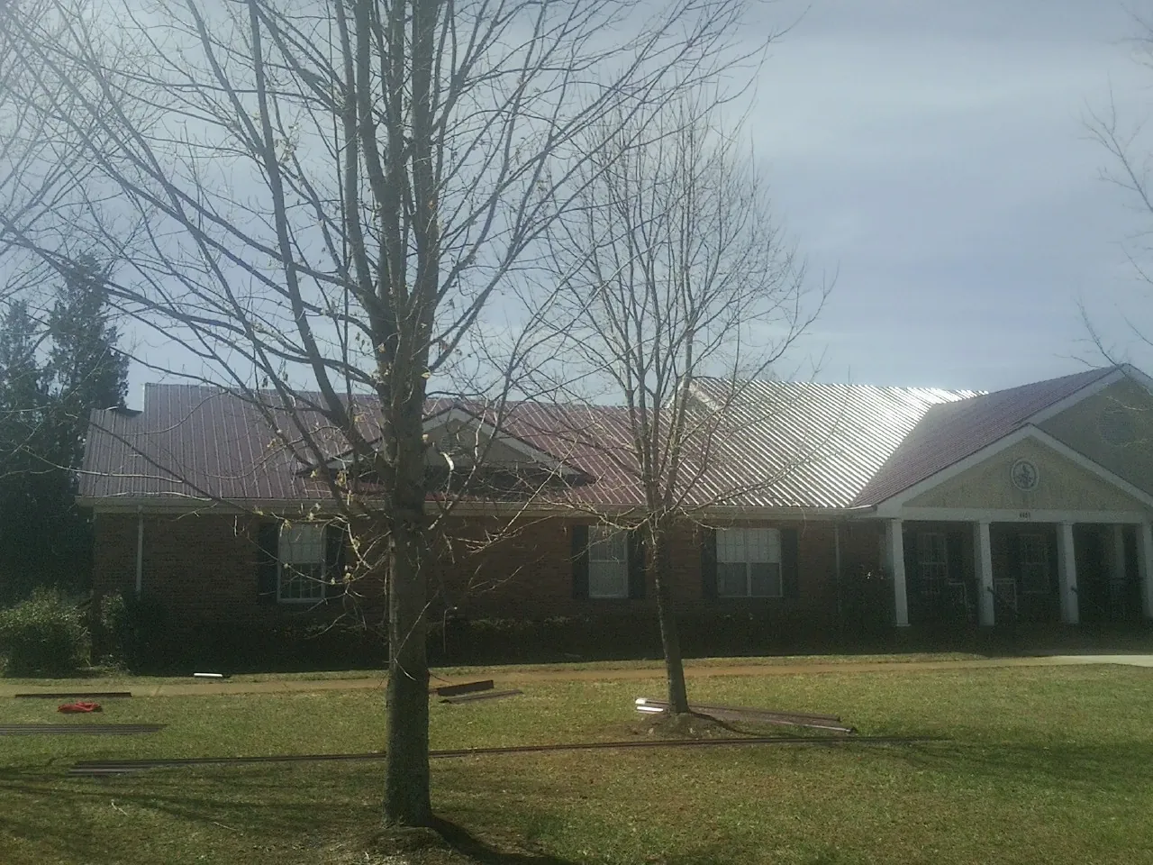 Red metal roof on a brick building seen from the front lawn in Climax