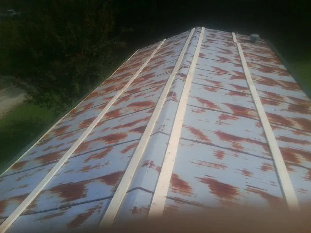 Rusted metal roof panels with new wood purlins before replacement — Storm Damage Roof Repair in Climax by Roofing Brothers